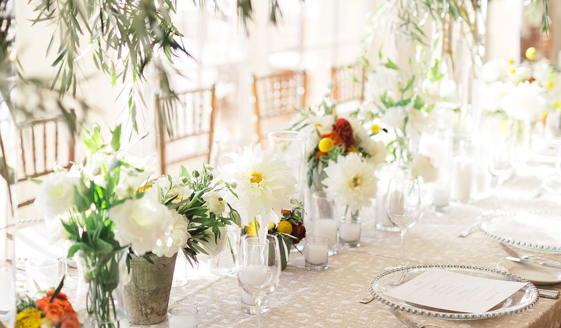 a dining table with elegant place settings and white flowers